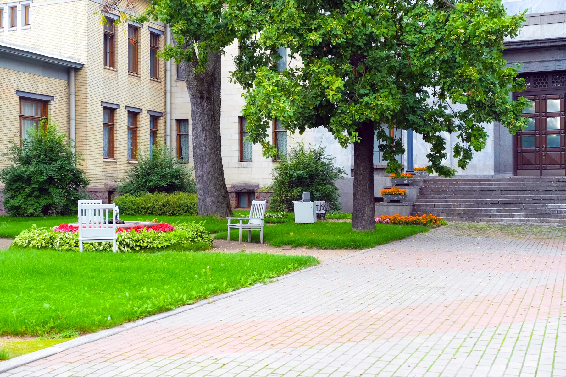Commercial building exterior with maintained lawn, trees, walkway, and landscaping