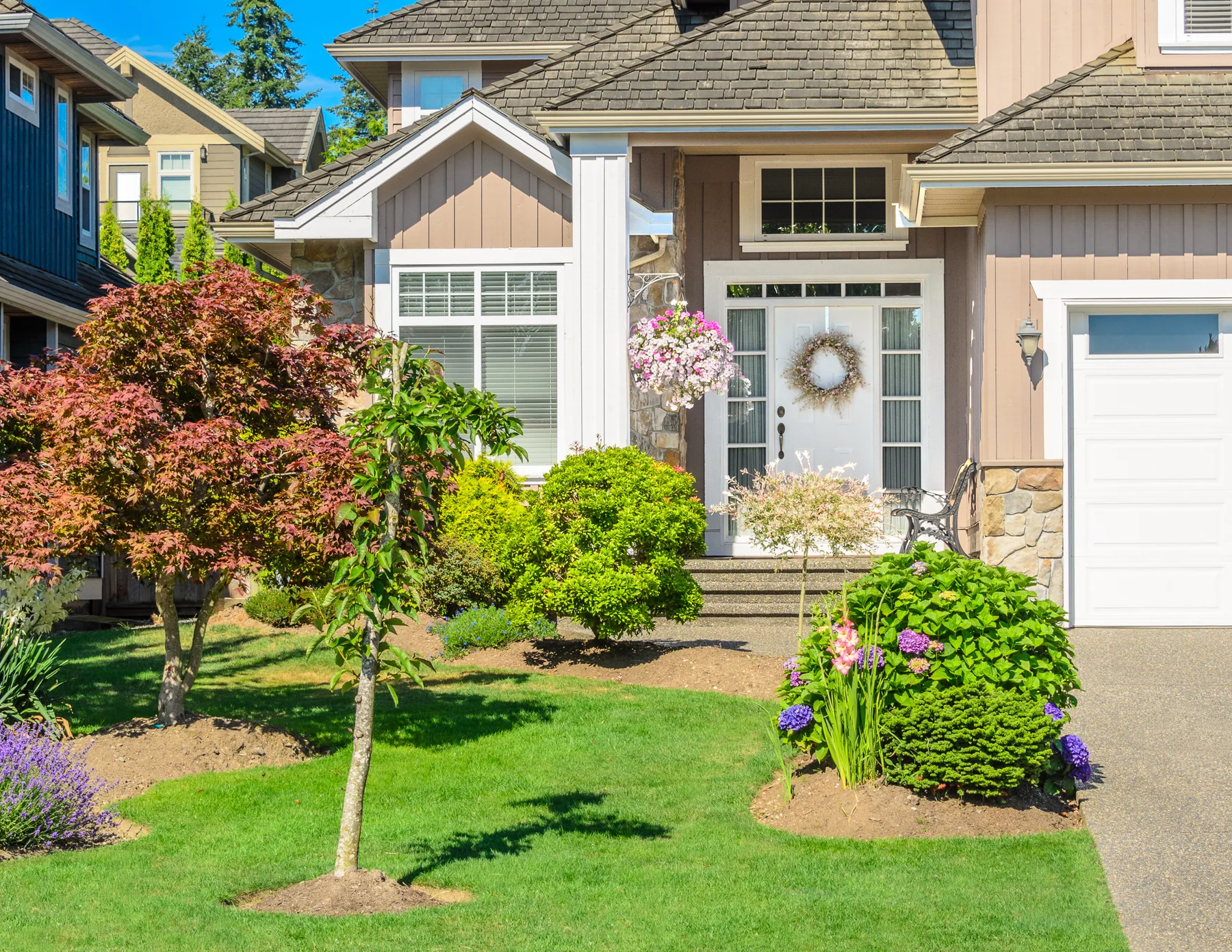 Residential property with maintained lawn, shrubs, and front landscaping
